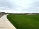 Scenic community park with lush green grass and walking path at 15781 W Beryl Ave, Waddell, AZ 85355
