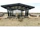 Shaded picnic area with tables and built-in benches, set amongst gravel and desert landscaping at 15781 W Beryl Ave, Waddell, AZ 85355
