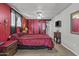 Bedroom with red walls, large bed, and a ceiling fan at 1707 S 72Nd St, Mesa, AZ 85209