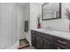 Bathroom with white-tiled shower and dark wood vanity at 1707 S 72Nd St, Mesa, AZ 85209