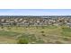 Scenic aerial view of a community with a golf course, homes, and mountain views in the distance at 1707 S 72Nd St, Mesa, AZ 85209