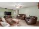 Comfortable living room featuring leather furniture, ceiling fan and access to the front door at 2003 W Tyson St, Chandler, AZ 85224