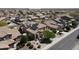 Aerial shot of a home with solar panels, detailed landscaping, and a view of a community with well-maintained streets at 22022 W Moonlight Path, Buckeye, AZ 85326