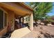 Covered back patio with ceiling fans and a beautiful seating area with stone pavers and decor at 22022 W Moonlight Path, Buckeye, AZ 85326