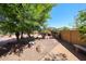Landscaped backyard showcasing stone pavers, mature trees, desert landscaping, and a bench at 22022 W Moonlight Path, Buckeye, AZ 85326