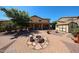 Expansive backyard featuring fire pit, covered patio, storage shed, and desert landscaping at 22022 W Moonlight Path, Buckeye, AZ 85326