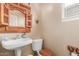 Half bathroom with pedestal sink, decorative mirror, and tiled flooring at 22022 W Moonlight Path, Buckeye, AZ 85326