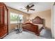 Neutral bedroom with ceiling fan, large window, and exercise equipment at 22022 W Moonlight Path, Buckeye, AZ 85326