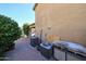 Exterior side view showcasing the home's AC units and a brick-paved walkway, complemented by lush foliage at 22022 W Moonlight Path, Buckeye, AZ 85326