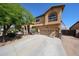 Attractive two-story home featuring a paved driveway, desert landscaping, and an arched entryway at 22022 W Moonlight Path, Buckeye, AZ 85326