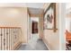 Hallway with wood railing, plush gray carpet and view of furniture at 22022 W Moonlight Path, Buckeye, AZ 85326