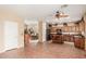 Open-concept kitchen boasts an island with seating and wood cabinets, seamlessly blending with the dining and living spaces at 22022 W Moonlight Path, Buckeye, AZ 85326
