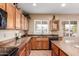 Well-lit kitchen with wooden cabinetry, granite countertops, and stainless steel appliances at 22022 W Moonlight Path, Buckeye, AZ 85326