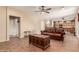 Spacious living room seamlessly connects with the kitchen, featuring a comfortable leather couch and unique coffee table at 22022 W Moonlight Path, Buckeye, AZ 85326