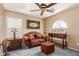 Cozy living room featuring a brown couch, and unique ceiling fan at 22022 W Moonlight Path, Buckeye, AZ 85326