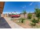 Backyard featuring a red truck, mature trees, and concrete landscaping at 2207 N 53Rd Ave, Phoenix, AZ 85035