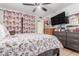 Cozy bedroom features a ceiling fan, floral accents, and natural lighting at 2207 N 53Rd Ave, Phoenix, AZ 85035