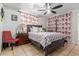 Comfortable bedroom boasts tiled floors, a ceiling fan, and floral patterned curtains at 2207 N 53Rd Ave, Phoenix, AZ 85035