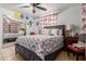 Bedroom featuring a bed with floral bedding, ceiling fan, and mirrored closet at 2207 N 53Rd Ave, Phoenix, AZ 85035