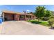 Exterior of home features a long driveway, a covered parking area, and a well-manicured lawn at 2207 N 53Rd Ave, Phoenix, AZ 85035