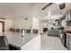 Open concept kitchen featuring a large quartz island with bar seating, stainless appliances, and tile floors at 2207 N 53Rd Ave, Phoenix, AZ 85035