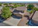 Elevated view of spacious home: showcasing a three car garage, lush landscaping, refreshing backyard pool and green grass at 2592 E San Rafael Trl, Casa Grande, AZ 85194