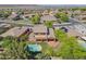 Aerial view of a private backyard featuring a sparkling pool, green lawn, mature trees, and a covered patio space at 2592 E San Rafael Trl, Casa Grande, AZ 85194