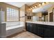 En suite bathroom with soaking tub, glass block window, dual sinks and large mirrors at 2592 E San Rafael Trl, Casa Grande, AZ 85194