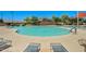Relaxing community pool and lounge area featuring a refreshing pool, comfortable seating, and clear blue skies above at 2592 E San Rafael Trl, Casa Grande, AZ 85194