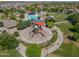 Aerial view of a community park and pool area showcasing playgrounds, covered seating, and green spaces at 2592 E San Rafael Trl, Casa Grande, AZ 85194