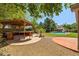 Custom backyard gazebo with bar seating, lush landscaping, patio space, pool and green grass for outdoor living at 2592 E San Rafael Trl, Casa Grande, AZ 85194