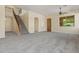 Bright, carpeted living room, showcasing staircase and stylish entry door, sets an inviting atmosphere for any home at 2592 E San Rafael Trl, Casa Grande, AZ 85194