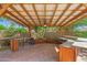 Covered outdoor kitchen with built-in bar, grill, and ceiling fan at 2592 E San Rafael Trl, Casa Grande, AZ 85194