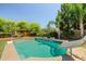 Backyard pool featuring a slide, basketball hoop, lush green grass and ample space for outdoor entertaining at 2592 E San Rafael Trl, Casa Grande, AZ 85194