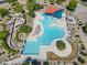 Aerial view of a large community pool with slides and covered seating areas surrounded by desert landscaping at 2592 E San Rafael Trl, Casa Grande, AZ 85194