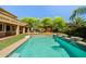 Backyard pool featuring a basketball hoop, lush green grass, well maintained landscaping and ample patio space at 2592 E San Rafael Trl, Casa Grande, AZ 85194