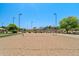 View of the sand volleyball court, with the pool and shaded seating visible in the background at 2592 E San Rafael Trl, Casa Grande, AZ 85194