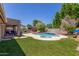 The backyard features a sparkling pool, lush landscaping, and a covered patio, ideal for outdoor relaxation and entertainment at 3060 E Hope St, Mesa, AZ 85213