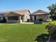 Spacious backyard with artificial turf, patio and mature trees creating a private outdoor oasis at 3060 E Hope St, Mesa, AZ 85213