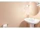 This is a pedestal sink and bathroom with round mirror, lighting and towel rack at 3060 E Hope St, Mesa, AZ 85213