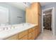 Bathroom with double sinks, cabinets and mirror, complemented by neutral tile floors at 3060 E Hope St, Mesa, AZ 85213