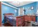 A bedroom featuring hardwood floors, a wood-framed bed, and blue-painted walls at 3060 E Hope St, Mesa, AZ 85213