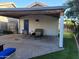 Covered patio with chairs and a table overlooking a green space, perfect for relaxation and outdoor activities at 3060 E Hope St, Mesa, AZ 85213