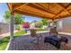 Covered patio provides a relaxing outdoor space, overlooking a pool, manicured lawn, and colorful landscaping at 3060 E Hope St, Mesa, AZ 85213