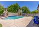 This beautiful pool features a tiled spillover spa, concrete decking, and well-maintained landscaping for luxurious outdoor living at 3060 E Hope St, Mesa, AZ 85213