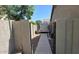 A fenced side yard features a pathway, gravel, AC equipment, and a gate; great for extra storage space at 3060 E Hope St, Mesa, AZ 85213