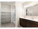 Bathroom with double vanity, large mirror, walk-in shower, and built-in storage shelves at 35266 W San Sisto Ave, Maricopa, AZ 85138