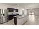 Modern kitchen with stainless steel appliances, granite countertops, and a center island overlooking the living area at 35266 W San Sisto Ave, Maricopa, AZ 85138