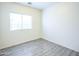 Minimal bedroom featuring luxury vinyl tile and a window with white blinds at 35721 N Zachary Rd, Queen Creek, AZ 85144