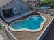Backyard view of private pool with rock landscaping and covered patio in secure block-fenced yard at 35721 N Zachary Rd, Queen Creek, AZ 85144